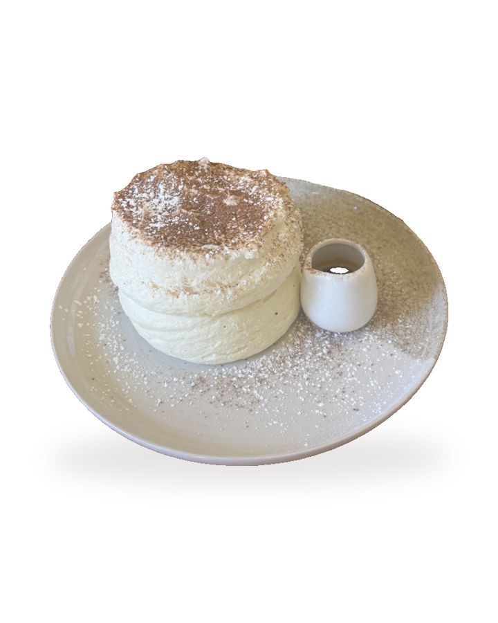 Fluffy pancake tiramisu saupoudré de cacao, servi avec un pot de café